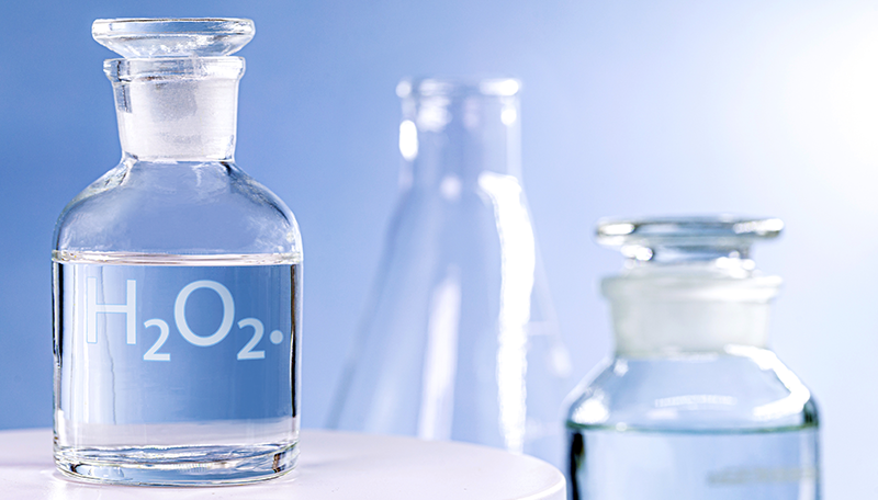 Glazen flesje met waterstofperoxide voor spoelen op een schone, witte ondergrond
