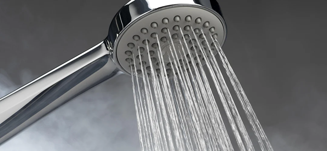 Foto eines Duschkopfs mit Dampf im Hintergrund